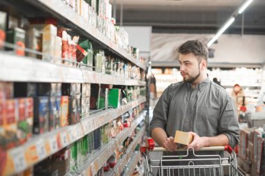 Bir süpermarkette Olgun kadın çay seçimi