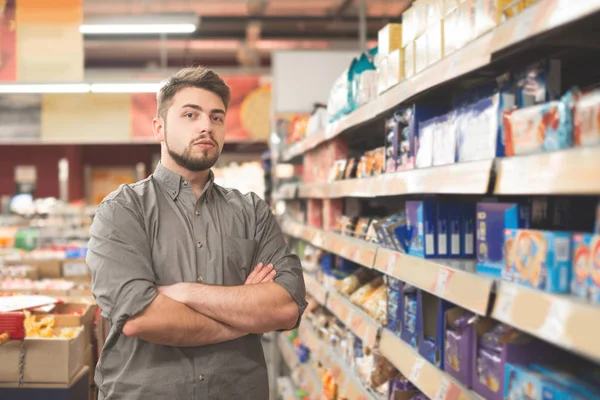 Portré jóképű férfi ügyfél, aki áll jegyzet lista szupermarket. — Stock Fotó