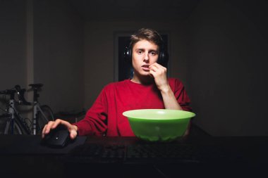 Genç adam gece bir bilgisayar sahiptir ve bir odada evde Fast Food yiyor, ekrana bakarak odaklanır. Teen gece bir bilgisayarda video oyunları oynar ve cips yiyor, kamera içine bir bakış