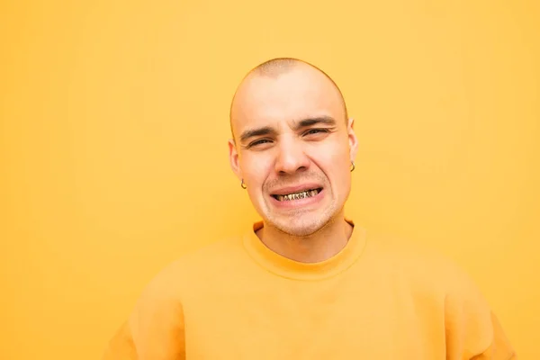 Chico gracioso de la parrilla en sus dientes mira a la cámara y m —  Fotos de Stock