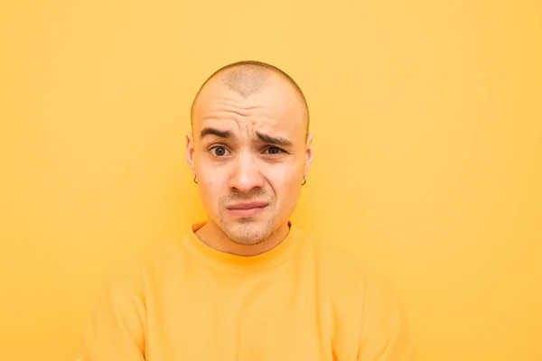 Amazed funny guy is isolated on a yellow background. Crazy man. Lost my mind. Stress, shock. Young emotional surprised man and surprised. Human emotions, facial expression concept. April fools day