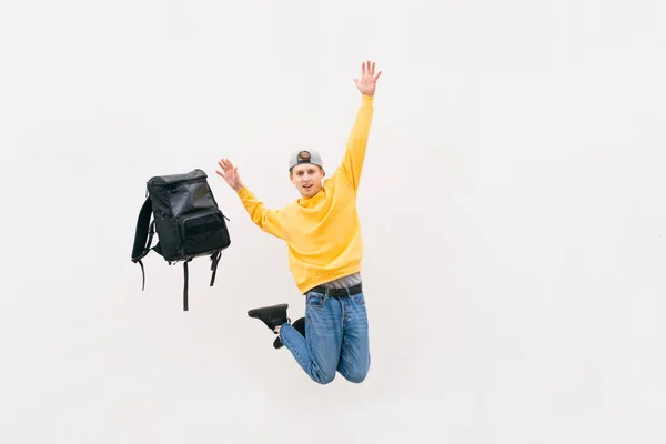 Joven de la calle saltando con una mochila en el fondo de una pared blanca. Aislado. Copyspace. Ingravidez. Levitación —  Fotos de Stock