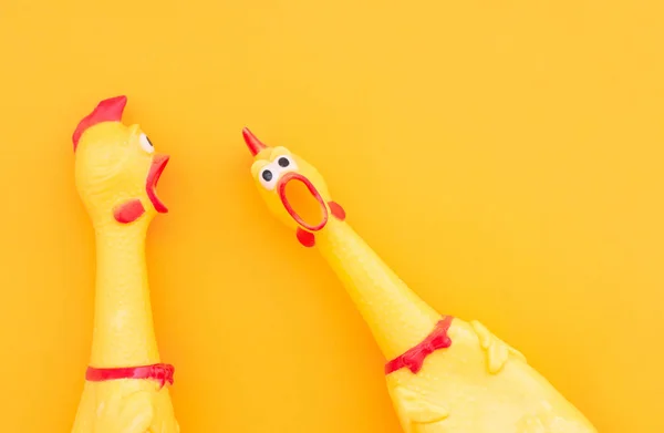 Surprised chicken toys are isolated on a orange background, one