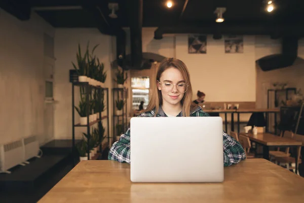 Ділова жінка використовує ноутбук у кафе. Молода красива дівчина сидить — стокове фото