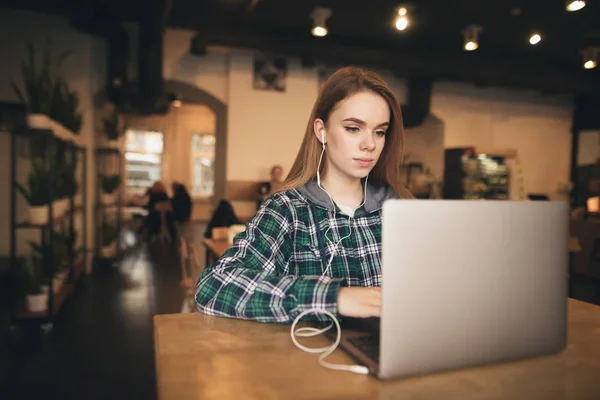 Концентрована красива дівчина в повсякденному одязі сидить в кафе з — стокове фото
