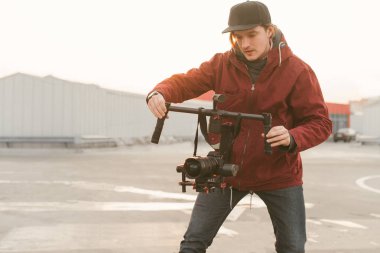 Kameracı sürekli cam kullanıyor. Elinde bir stabilizatör ile kameraman yaratıcısı bir video alır DSLR gün batımı arka planda kamera. Video konsepti oluşturma.
