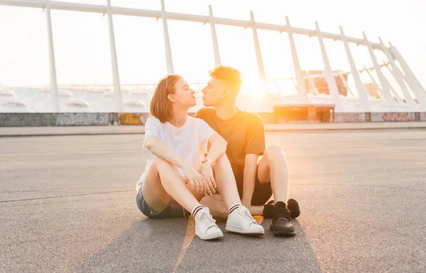 Livsstilskoncept. porträtt av ett ungt par mot bakgrund av ett stadslandskap vid solnedgången. Vackra kärleksfulla par tillbringar kvällen tillsammans på bakgrunden av en vacker utsikt — Stockfoto