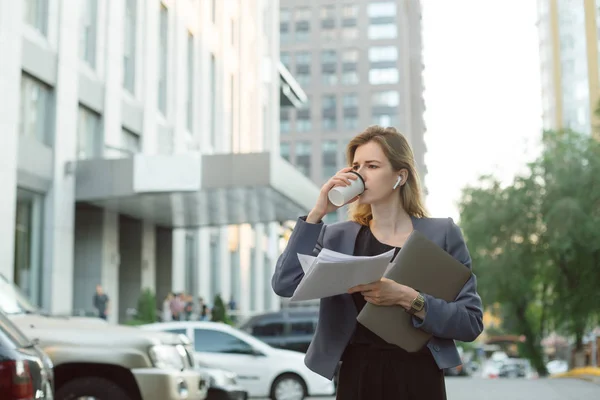 Mujer de negocios serio beber café cerca del edificio de oficinas h — Foto de Stock