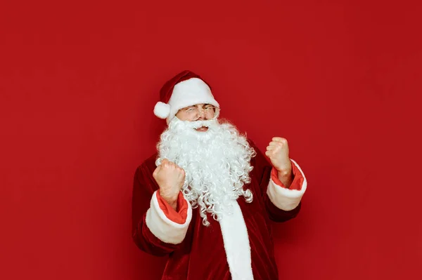 Retrato de la alegría de Santa Claus se regocija en la victoria sobre el fondo rojo. Santa es feliz, gritando y gesticulando activamente con alegría. Aislado. Concepto X-mas. Espacio de copia . — Foto de Stock