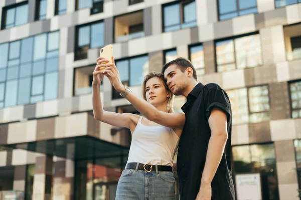 Bela jovem casal em roupas elegantes fazendo selfie ao ar livre — Fotografia de Stock