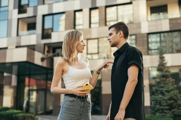 Stylish young man and attractive girl standing on the street tal — Stock Photo, Image