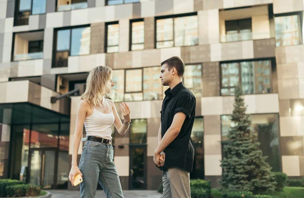 Stylish young people guy and girl standing on the street against — ストック写真