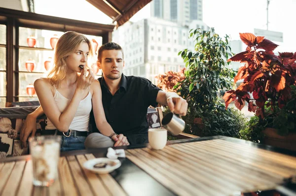 Hermosa pareja sentada en la terraza en el restaurante al atardecer —  Fotos de Stock