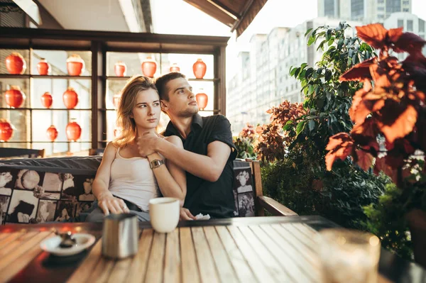 Retrato de pareja amorosa joven abrazándose en la terraza en la cafetería con —  Fotos de Stock