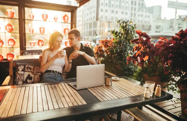 Handsome young man and girl sitting at table in cozy restaurant — Stock Photo, Image