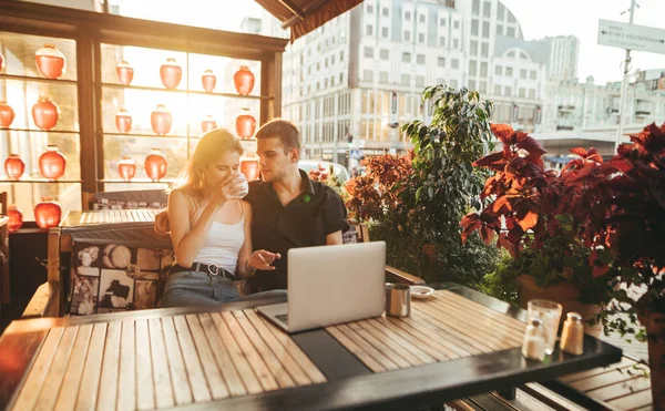 Casal bonito sentado ao pôr do sol no terraço no café da cidade com — Fotografia de Stock