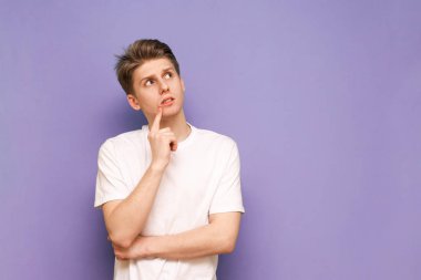 Düşünceli bir gencin portresi beyaz bir tişört giyer.