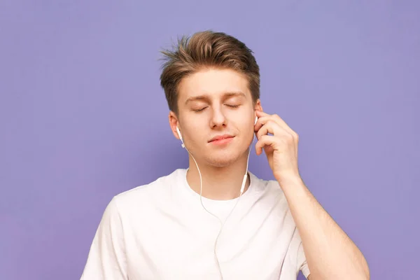 Retrato de cerca de un tipo escucha música en sus auriculares wi — Foto de Stock