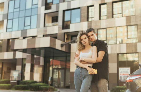 Young Family Stands Street Backdrop Modern Apartment Building Hugging Looking — Stock Photo, Image
