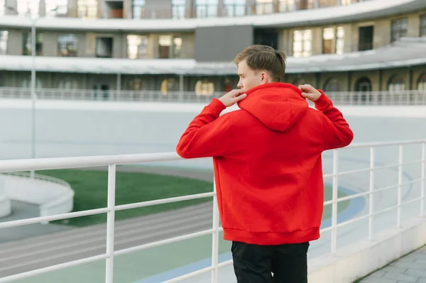 Jongeman Met Een Rode Capuchon Poserend Een Camerarek Achtergrond Van — Stockfoto