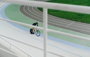 Bisikletçi ve raylı trenler boş bir velodromda. Hobi olarak bisiklete binmek. Velodrome 'un bisiklet eğitimi. Üst görünüm, arkaplan