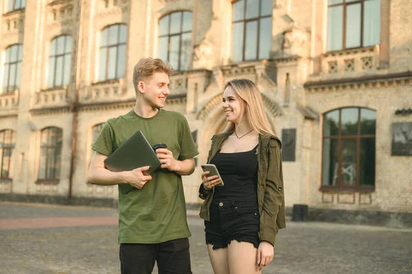 거리에 학생들 노트북 스마트폰을 대학교 건물의 서로를 바라보며 미소짓고 학생들 — 스톡 사진