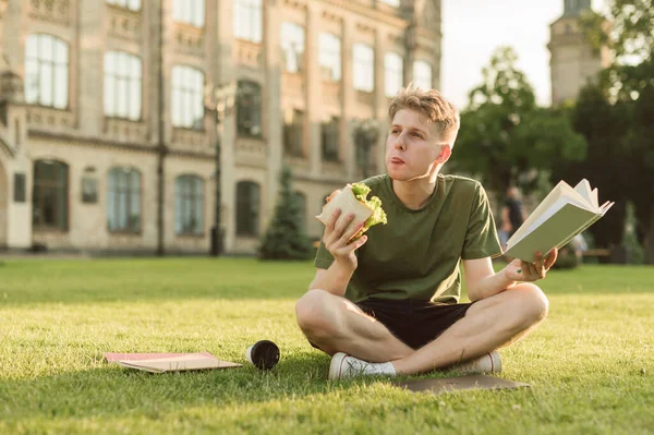 Funny Young Man Reading Book College Break Eating Delicious Sandwich — Stock Photo, Image