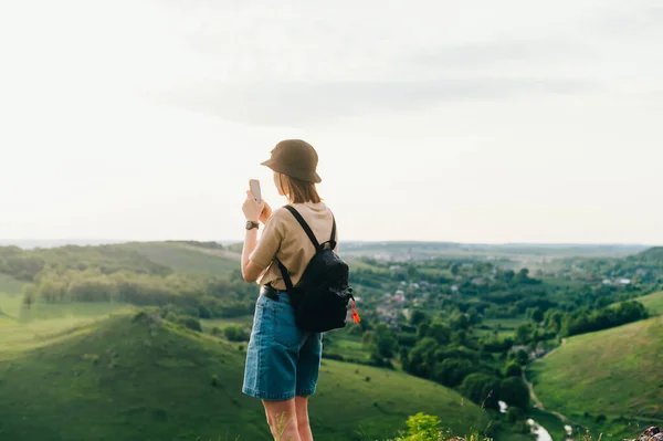 Туристка Рюкзаком Стоїть Пагорбі Чудовим Ландшафтом Фотографує Смартфон Заході Сонця — стокове фото