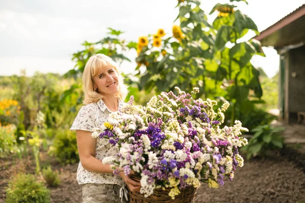 Mujer Feliz Está Pie Con Una Cesta Flores Cultivadas Sus —  Fotos de Stock