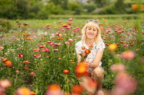 Positive Blonde Woman Sitting Flowerbed Dried Flowers Smiling Woman Sitting Royalty Free Stock Images