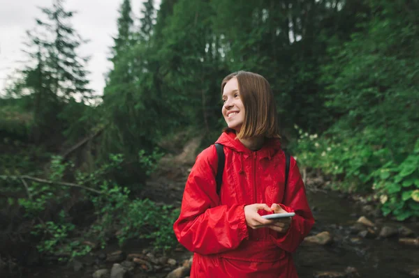Una Joven Excursionista Con Impermeable Rojo Sonríe Sosteniendo Teléfono Sus — Foto de Stock