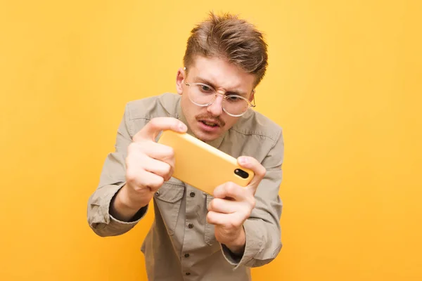 Retrato Joven Expresivo Gafas Camisa Utiliza Teléfono Inteligente Sobre Fondo — Foto de Stock