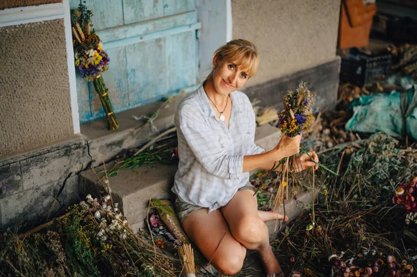 Florista Femenina Positiva Sentada Campo Medio Una Cosecha Flores Secas —  Fotos de Stock