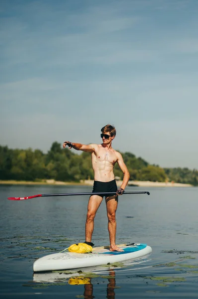 Guapo Joven Que Divierte Sup Board Con Paleta Mano Mostrando — Foto de Stock