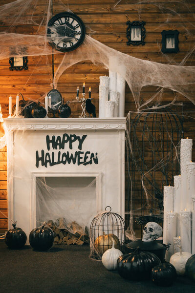 Cozy decorations in the interior for Halloween with a fireplace and festive attributes. Photozone for Halloween. Background Vertical