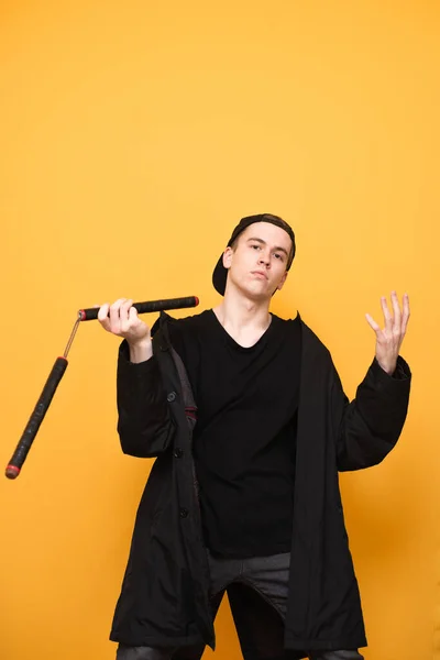 Retrato Jovem Roupas Pretas Treina Com Nunchakus Fundo Amarelo Olha — Fotografia de Stock