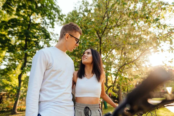一对穿着休闲装的年轻貌美的情侣站在秋天的公园里 相互拥抱 面带微笑地望着对方 一个女人和一个男人散步时的闲暇 — 图库照片