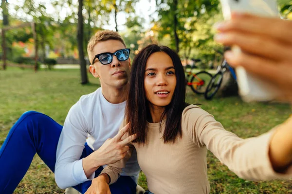 Hermosa Pareja Joven Sentada Césped Parque Tomando Una Selfie Teléfono — Foto de Stock