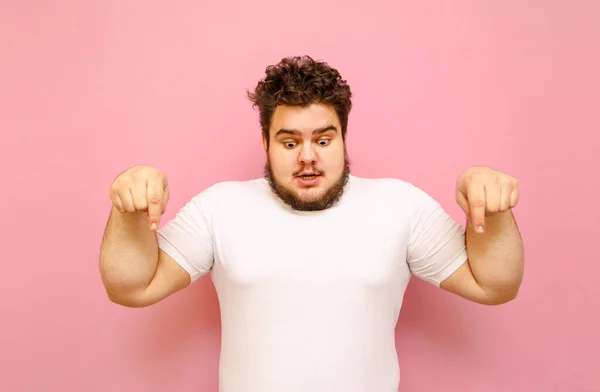 Chockad Överviktig Kille Vit Shirt Isolerad Rosa Bakgrund Ser Ner — Stockfoto