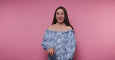 Canlı bir ortamda, genç bir kadın kendine güven ve neşe saçar, çekici bir gülümseme ile eğlenceli bir poz verir ve son moda bir şekilde omuz üstü giyinir..