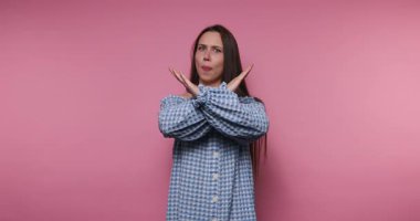 Genç bir kadın, canlı pembe bir arkaplan karşısında bir dizi neşeli duygu sergiliyor. Şık bir damalı kıyafet giyiyor ve güzel jestler yapıyor. Eğlenceli bir ortam yaratıyor..