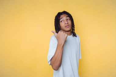 Düşünceli bir duruş sergileyen genç adamın portresi sarı arka planda başparmağıyla gösteriliyor.