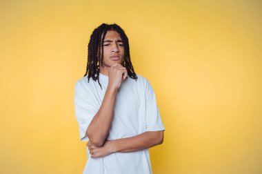 Genç adamın portresi belirsiz ve şaşkın görünüyor. Mücadelelerini sarı arka planda bir oyun bağlamında bir kararla gösteriyor.