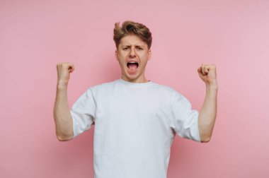 Genç adamın portresi coşkulu bir şekilde sevinç ve heyecan ifade ediyor. Pembe arka planda pozitif enerji sergiliyor.