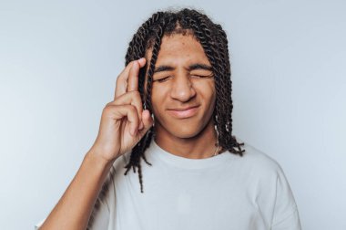 Genç bir adamın portresi şans dilerken görülüyor. Beyaz arka planda umut ve pozitiflik yayıyor.