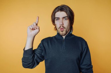 Genç adamın portresi, şevkle yukarı doğru bakıyor sarı arka planda şaşırmış bir ifadeyle.