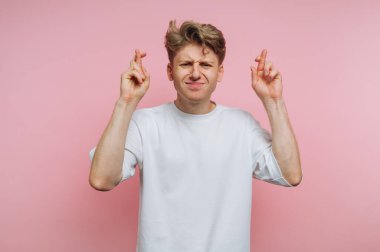 Pembe zemin üzerinde umut ve pozitifliği sembolize eden pembe bir zemin üzerinde beklenti içinde genç bir adamın portresi