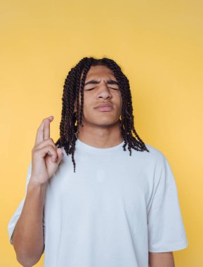 Saçları örgülü genç bir adamın portresi. Sarı arka planda umut ve pozitifliği ifade ediyor.