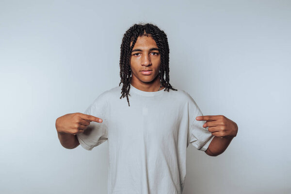 портрет молодого человека уверенно указывая на себя, подчеркивая индивидуальность на белом фоне