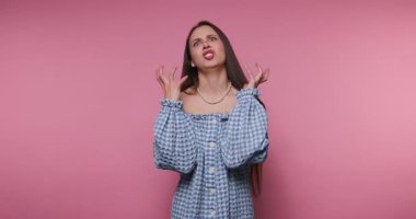 Genç bir kadının görüntüsü pembe arka planda şık bir kıyafetle hayal kırıklığını çarpıcı bir şekilde ifade ediyor.